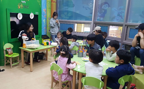 아이들에게 소품을 이용해 팝콘만들기 보여주는 모습